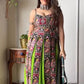 Woman wearing a colorful traditional outfit with a green dupatta indoors.