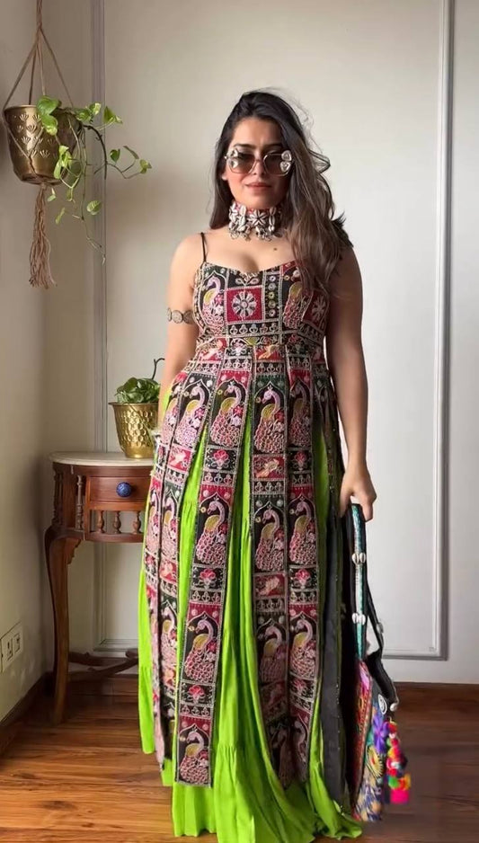 Woman wearing a colorful traditional outfit with a green dupatta indoors.